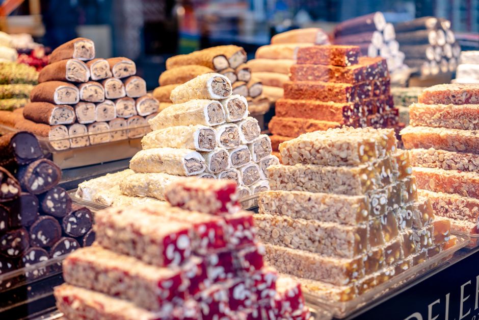 A vibrant assortment of Turkish delight candies stacked in a market display, showcasing variety and color.